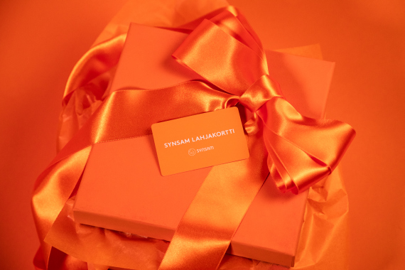 Oranssi tausta, oranssi lahjapaketti ja urheilulasit