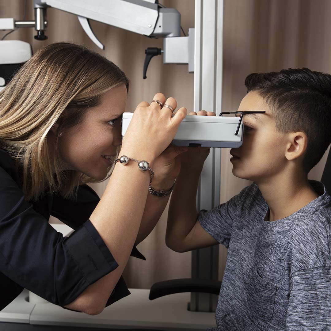 Kvinna som gör synundersökning på ett barn.